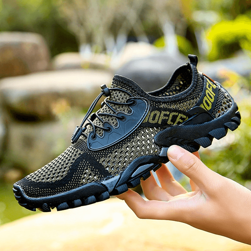 Breathable elastic camping shoe for men, SF0827, shown in a person's hand, featuring a mesh upper and durable rubber outsole.